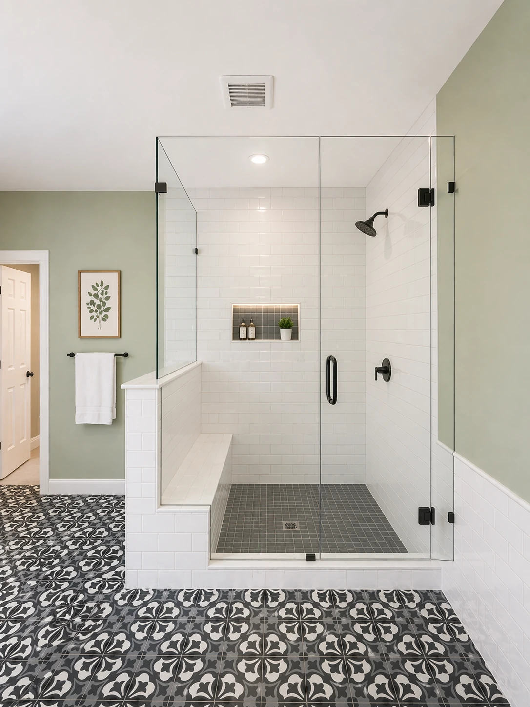 Homestead Place primary bathroom walk-in shower — white subway tile with built-in bench, black fixtures, and patterned cement tile