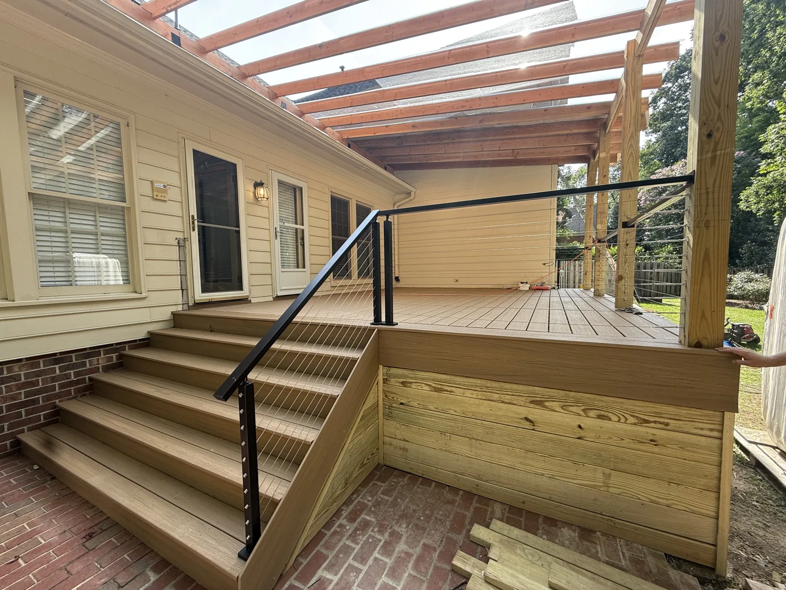 Cable-rail Trex deck with pergola on SkyLift roof risers above the roofline — Starmount outdoor living project by Salem Builders